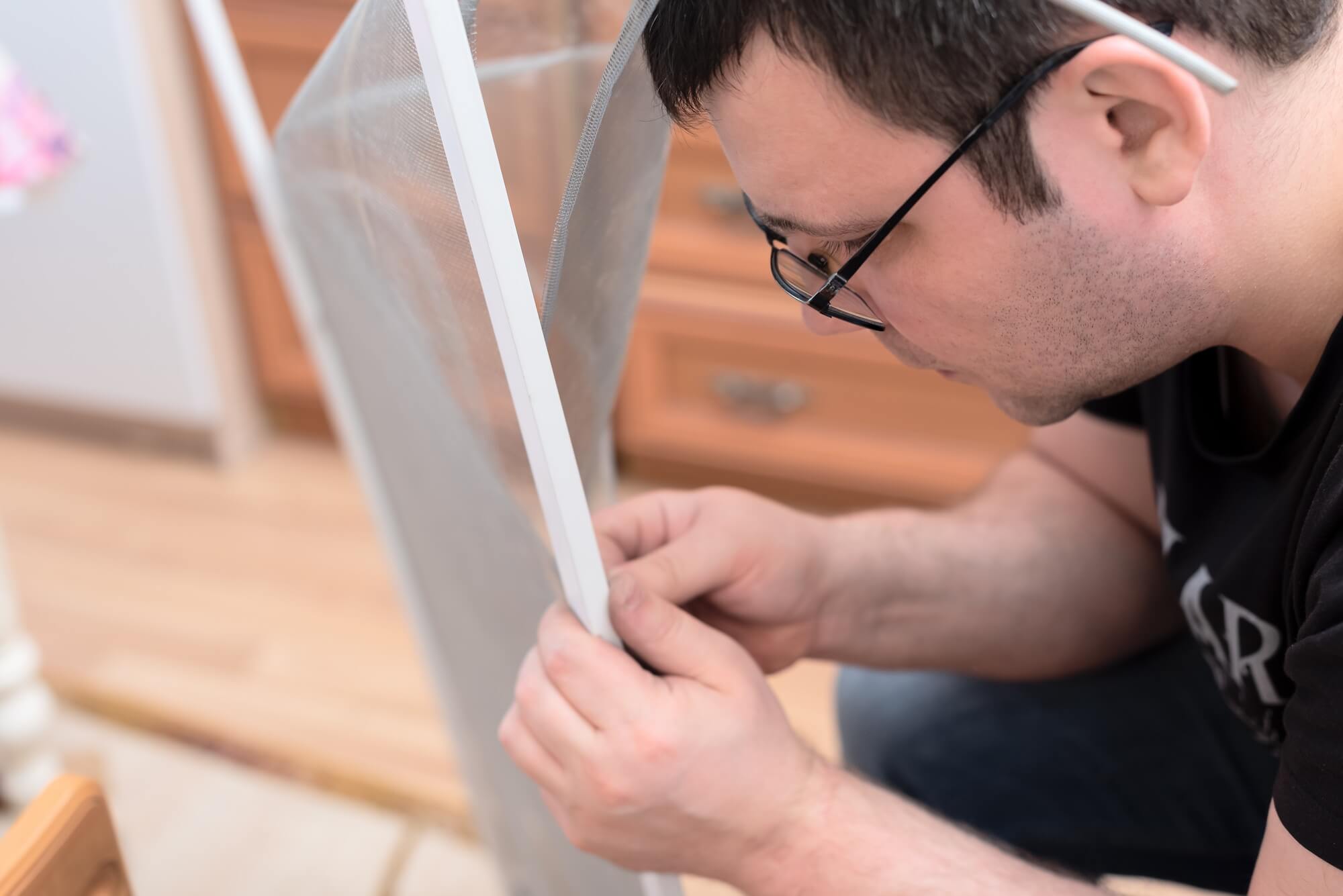 man-repairing-mosquito-net-at-home-home-improvement-concept-.jpg